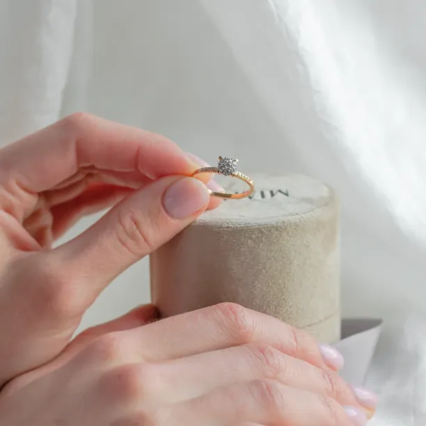 Pavé gold ring with moissanites held between fingers