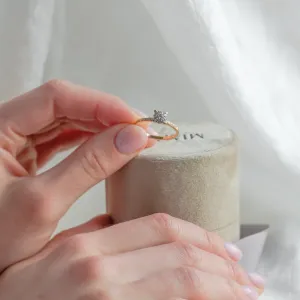 Pavé gold ring with moissanites held between fingers