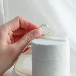 AVELA gold ring with three lab-grown diamonds held between fingers