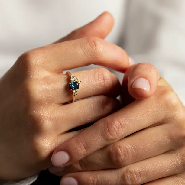Close-up of the VAIANA gold cluster ring worn on a finger