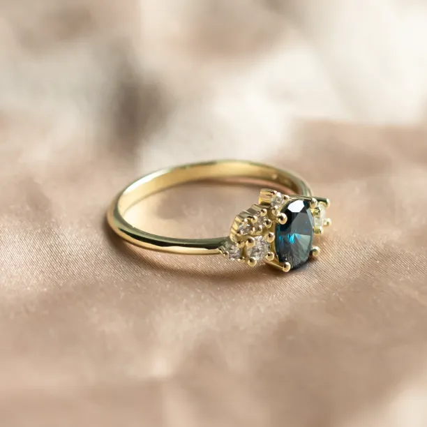 Angled view of the VAIANA gold ring showing its blue and white diamond cluster