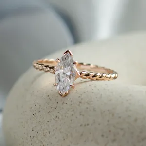 Angled view of the gold twisted rope ring and marquise-cut moissanite