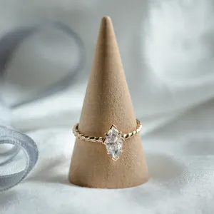 Gold twisted rope ring with marquise-cut moissanite on a display stand