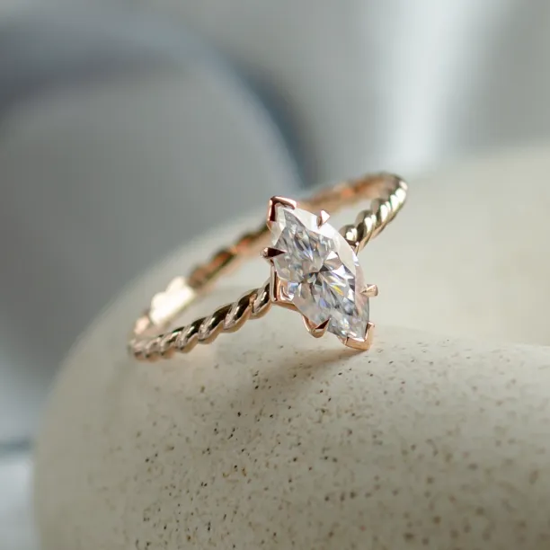 Close-up of the DAHLIA gold twisted rope ring and marquise-cut moissanite