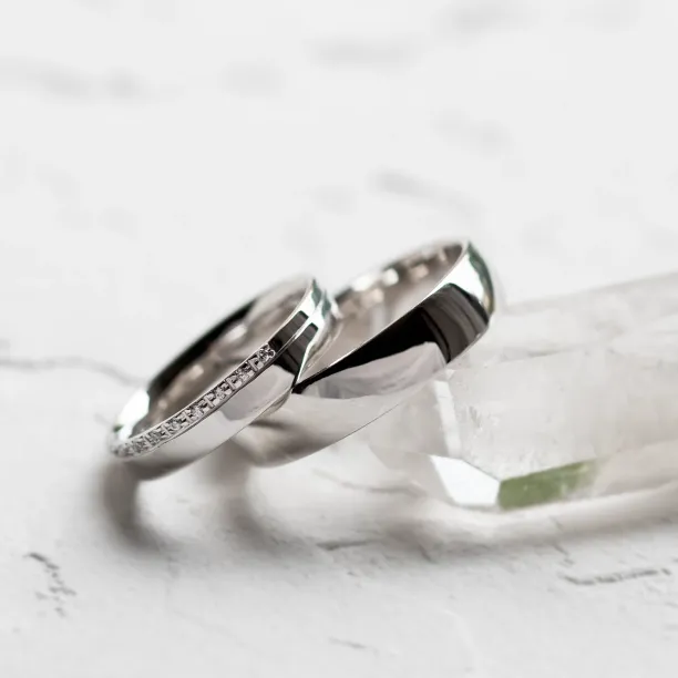 Angled view of TRADITIO diamond wedding rings with a plain band