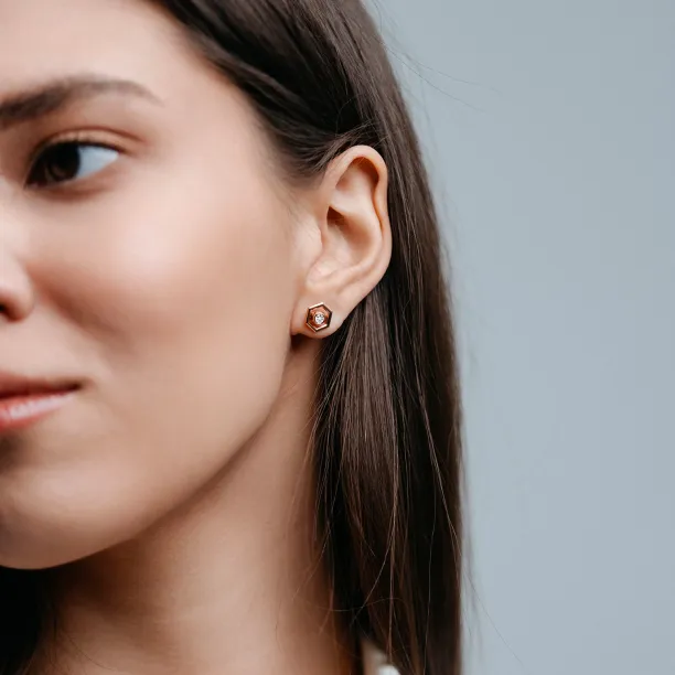 SAM gold hexagonal earring with removable gemstone worn on the ear