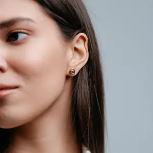 Gold hexagonal earring worn on the ear