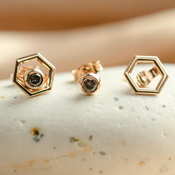 Gold hexagonal earrings shown with a removable gemstone