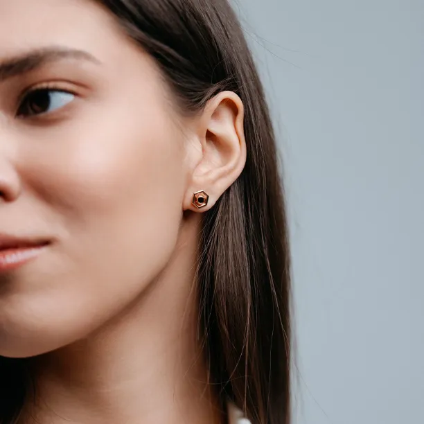 SAM gold hexagonal earring worn on the ear without its central gemstone