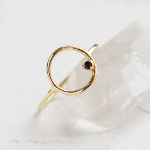 Close-up of the circular setting and red garnet on the MERIDAL ring