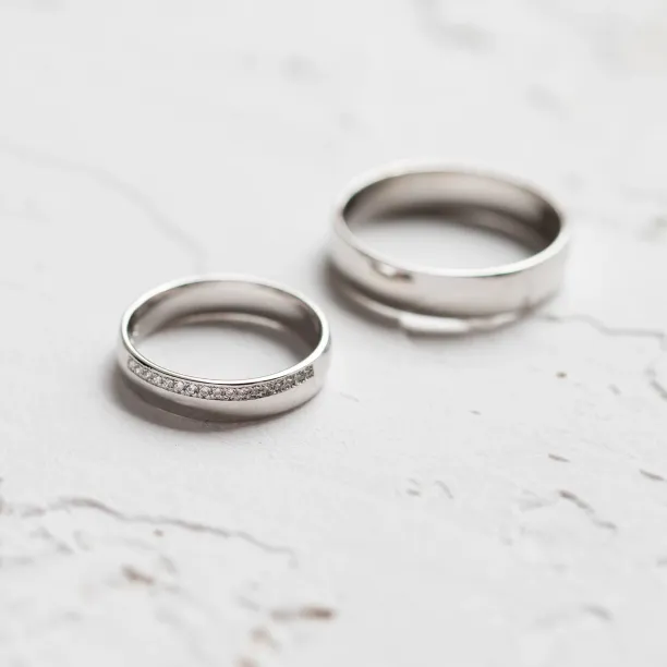 Separated TRADITION wedding rings, with the diamond-set women's ring in front