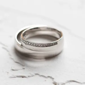 Close-up of overlapping TRADITION wedding rings with a diamond-set women's ring