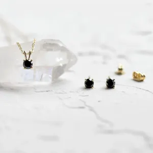 Black diamond stud earrings shown beside a matching pendant
