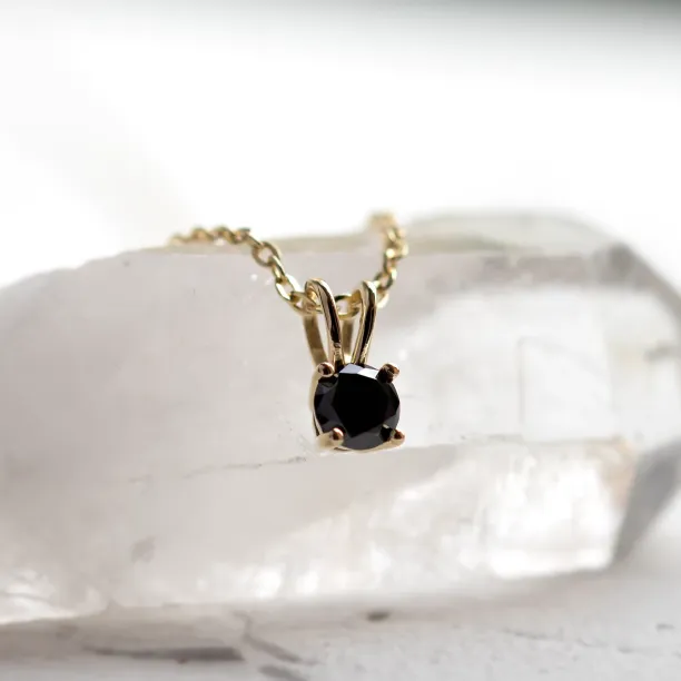 Detailní záběr zlatého přívěsku BLADE s černým diamantem