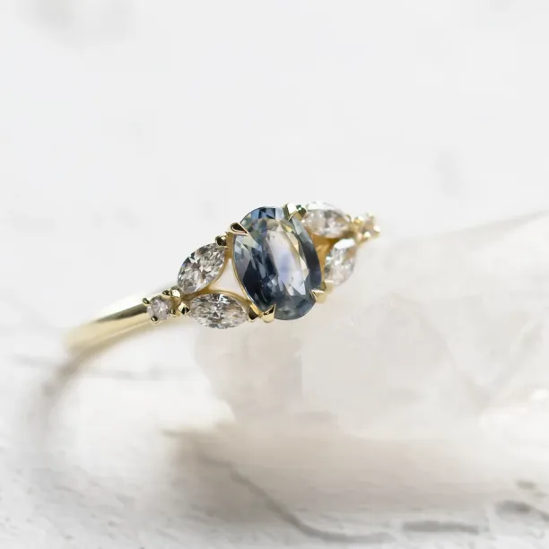 Šikmý detailní záběr na prsten s oválným safírem a diamanty
