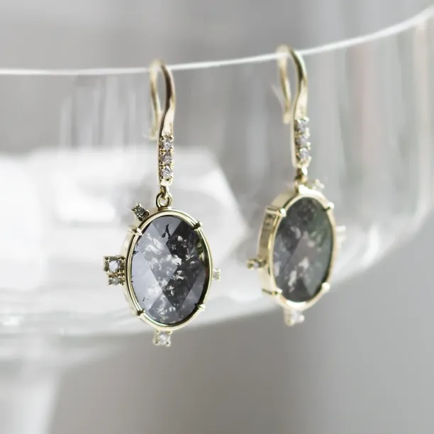 Close-up of MARIBEL earrings with oval salt and pepper diamonds