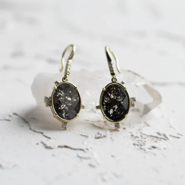 Close-up of MARIBEL gold earrings with oval salt and pepper diamonds and classic diamonds