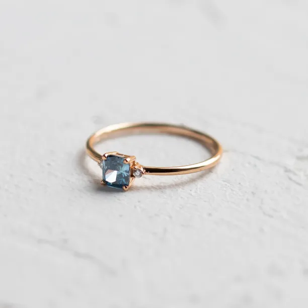 Close-up of the ARCTIS gold ring with a cushion-cut blue lab-grown diamond