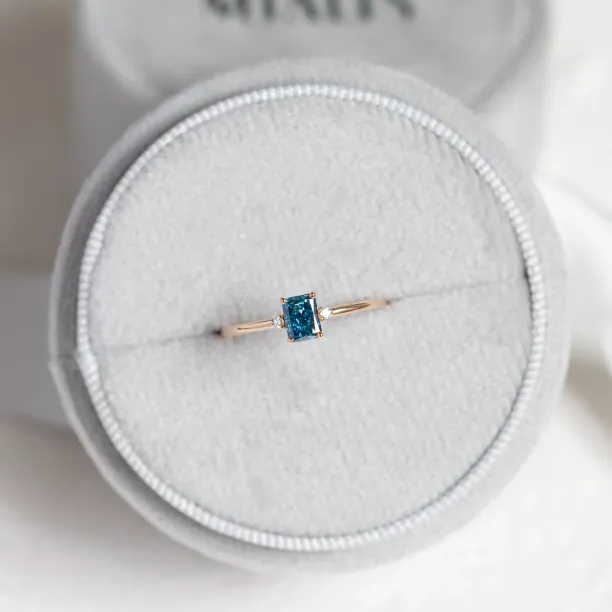ARCTIS gold ring with a blue lab-grown cushion-cut diamond and white diamonds, overhead view