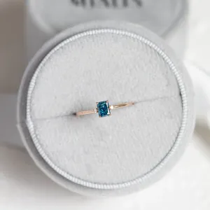 ARCTIS gold ring with a blue lab-grown cushion-cut diamond and white diamonds, overhead view