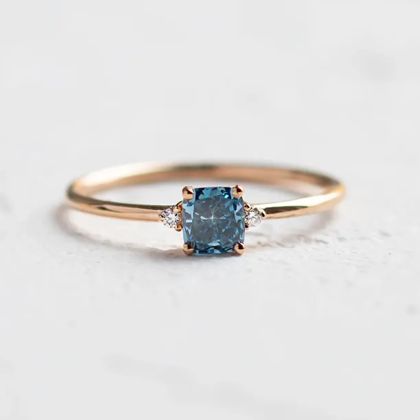 ARCTIS gold ring with a cushion-cut blue lab-grown diamond and white diamonds