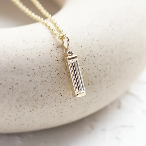 Angled close-up of the FELIANA pendant with baguette moissanite and diamond