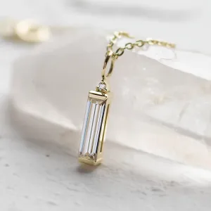 Close-up of the FELIANA gold pendant and its baguette moissanite