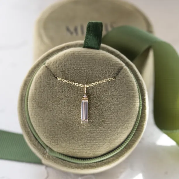 FELIANA pendant necklace displayed with a baguette moissanite and small diamond