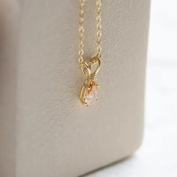 Side detail of the gold SOLARIS pendant and its two diamonds