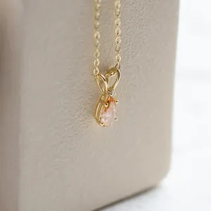 Side detail of the gold SOLARIS pendant and its two diamonds