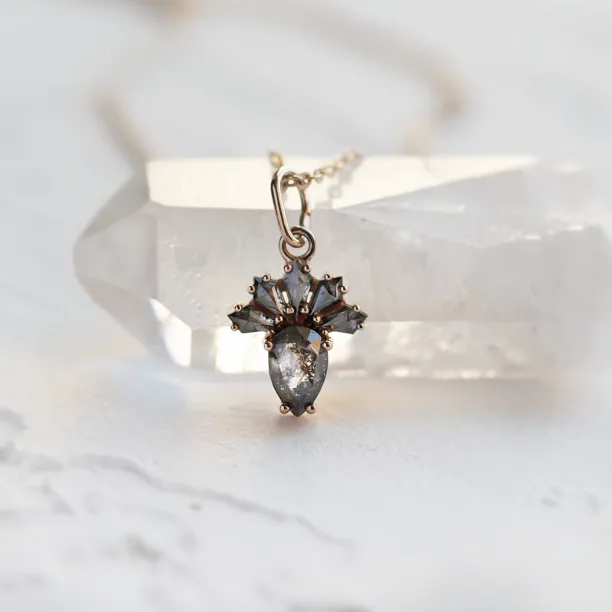 Close-up of the LONIA gold pendant with salt and pepper diamonds