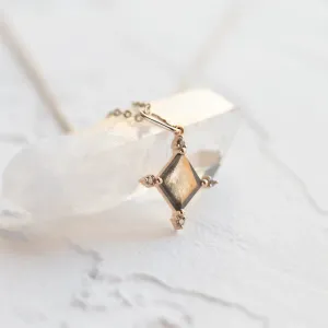 Angled close-up of the CRESSIDA necklace pendant and its faceted salt and pepper diamond