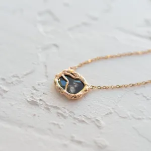 Angled close-up of the TREASURE salt and pepper diamond necklace pendant