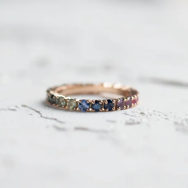 Rainbow sapphire eternity ring shown as a complete circle of colorful sapphires