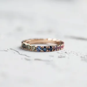 Rainbow sapphire eternity ring shown as a complete circle of colorful sapphires