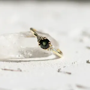 Detailní šikmý pohled na zásnubní prsten se zeleným safírem a diamanty