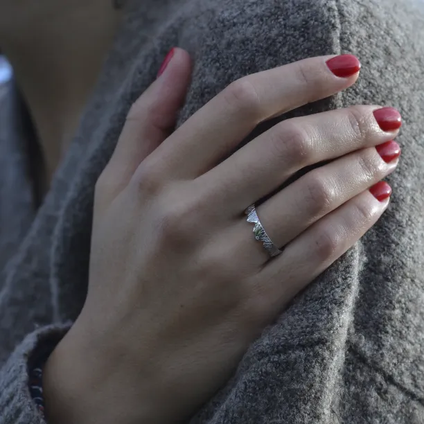 Platinum mountain-inspired wedding ring worn on a hand