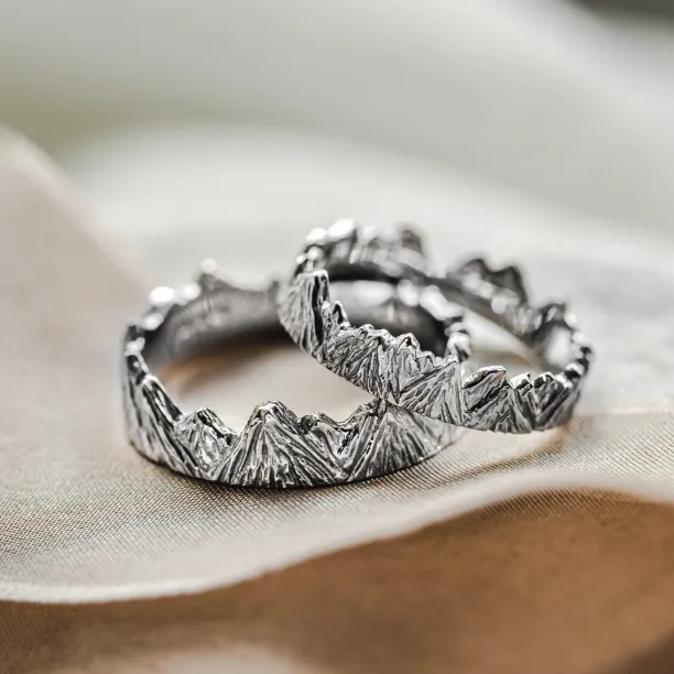 Angled view of MONTE platinum wedding rings with mountain motif