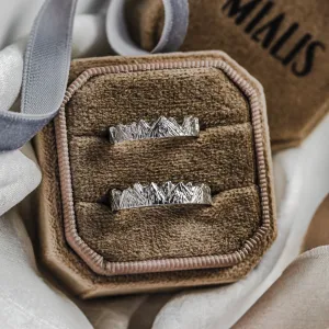 Top view of MONTE platinum mountain-inspired wedding rings in a box