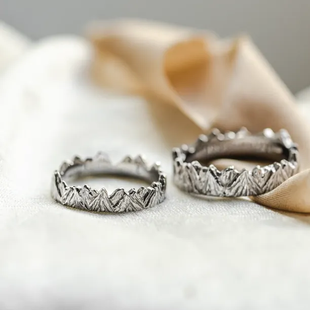 MONTE platinum mountain-inspired wedding rings, shown as a pair