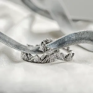 Close-up of MONTE platinum wedding rings with mountain-inspired bands