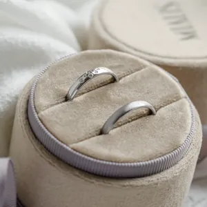 Angled view of LEOS platinum wedding rings, including the diamond-set ring