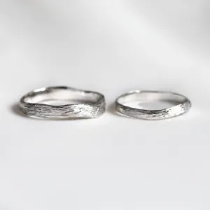 Pair of platinum twig wedding rings shown side by side