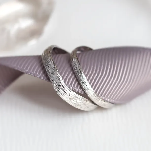 Angled close-up of the textured surface on platinum twig wedding rings