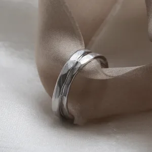 Close-up of ETA hammered platinum wedding bands on fabric
