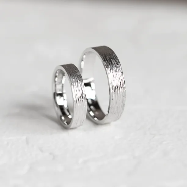 Platinum wedding bands in an angled view, showing their bark-like texture