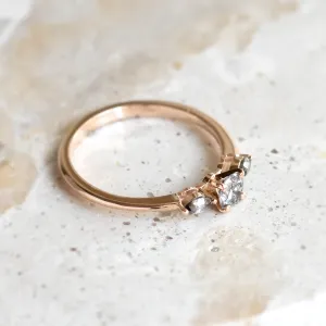 Angled view of RINA gold ring with three salt and pepper diamonds
