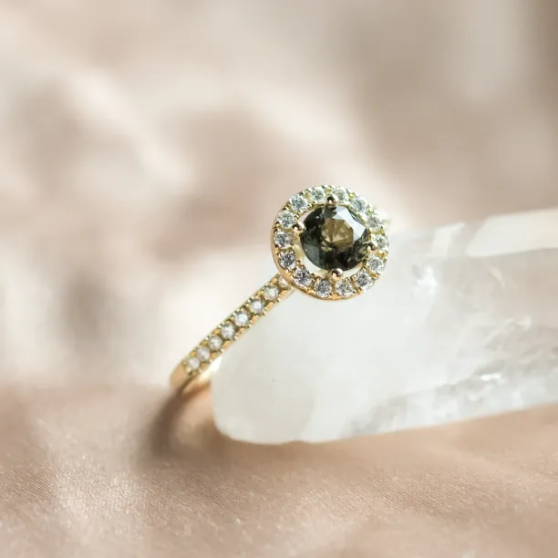 Detailní šikmý pohled na zlatý prsten s přírodním safírem a diamantovým halo