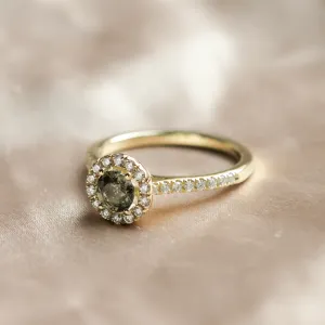 Šikmý detail zlatého prstenu s přírodním safírem a diamanty v halo stylu