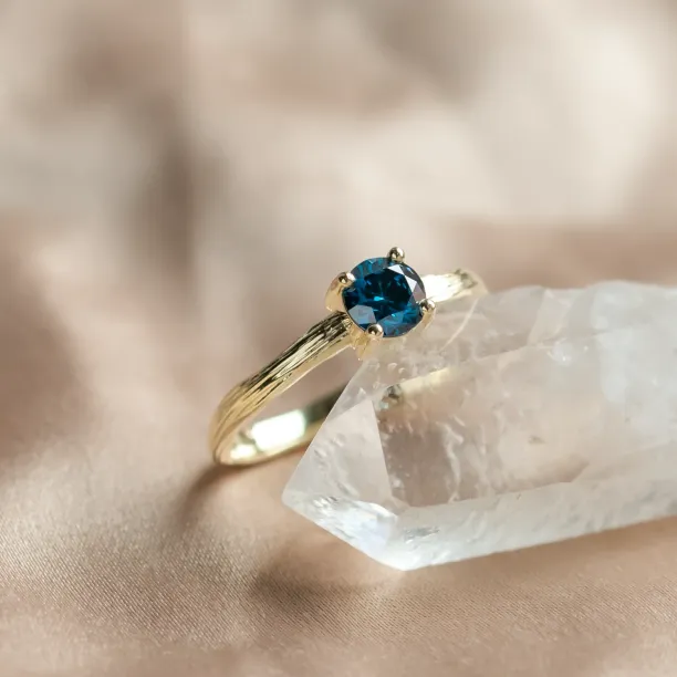 Angled close-up of the BLU engagement ring with a blue lab-grown diamond